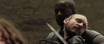 Movie still from “Doomsday” (2008), directed by Neil Marshall – A man holding a knife in front of another man's face; Close Up shot, Over the shoulder angle