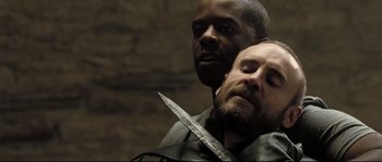 Movie still from “Doomsday” (2008), directed by Neil Marshall – A man holding a knife in front of another man's face; Close Up shot, Over the shoulder angle