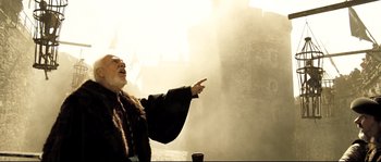Movie still from “Doomsday” (2008), directed by Neil Marshall – An old man pointing to something in the distance; Medium shot, Low angle