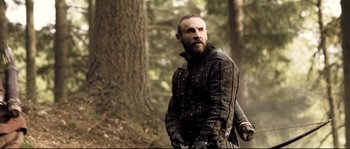 Movie still from “Doomsday” (2008), directed by Neil Marshall – A man in a leather jacket standing next to a tree; Medium shot, Low angle