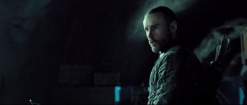 Movie still from “Doomsday” (2008), directed by Neil Marshall – A man standing in the dark looking to his left; Close Up shot, Over the shoulder angle