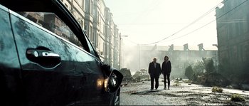Movie still from “Doomsday” (2008), directed by Neil Marshall – Two people walking down a street near a car; Wide shot, Low angle