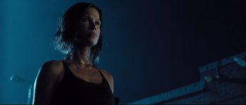 Movie still from “Doomsday” (2008), directed by Neil Marshall – A woman standing in the dark looking at the camera; Close Up shot, Low angle