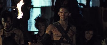 Movie still from “Doomsday” (2008), directed by Neil Marshall – A man and a woman are dressed in leather; Close Up shot, Over the shoulder angle