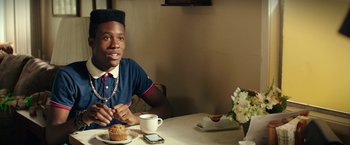 Movie still from “Dope” (2015), directed by Rick Famuyiwa – A man sitting at a table with a cup of coffee; Close Up shot, Over the shoulder angle
