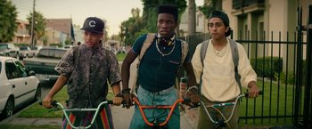 Movie still from “Dope” (2015), directed by Rick Famuyiwa – A group of young men standing next to each other; Medium shot, Over the shoulder angle
