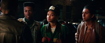 Movie still from “Dope” (2015), directed by Rick Famuyiwa – A young man wearing a hat in a crowd of people; Close Up shot, Over the shoulder angle