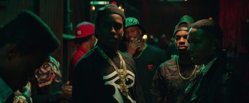 Movie still from “Dope” (2015), directed by Rick Famuyiwa – A group of men standing next to each other in a room; Medium shot, Over the shoulder angle