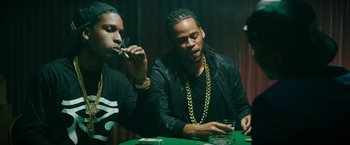 Movie still from “Dope” (2015), directed by Rick Famuyiwa – A couple of men sitting at a table with a cigarette; Medium shot, Low angle