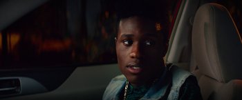 Movie still from “Dope” (2015), directed by Rick Famuyiwa – A man with a beard and a jacket on looking into the distance; Close Up shot, Over the shoulder angle