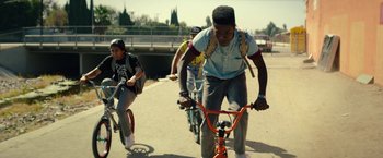 Movie still from “Dope” (2015), directed by Rick Famuyiwa – A group of young men riding bikes down a street; Medium shot, Low angle