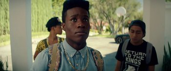 Movie still from “Dope” (2015), directed by Rick Famuyiwa – A young man with a gold chain around his neck; Close Up shot, Over the shoulder angle