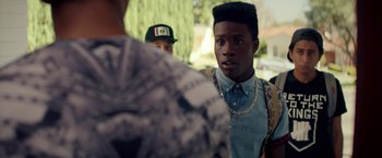 Movie still from “Dope” (2015), directed by Rick Famuyiwa – A man with a beard and a chain around his neck talking to another man; Close Up shot, Over the shoulder angle