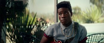 Movie still from “Dope” (2015), directed by Rick Famuyiwa – A man with a guitar in his hands; Close Up shot, Over the shoulder angle