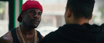 Movie still from “Dope” (2015), directed by Rick Famuyiwa – A man wearing a red hat talking to another man; Close Up shot, Over the shoulder angle