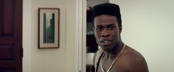 Movie still from “Dope” (2015), directed by Rick Famuyiwa – A young man with a large black afro is posing for a picture; Close Up shot, Over the shoulder angle