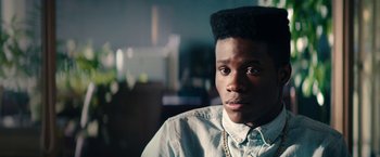 Movie still from “Dope” (2015), directed by Rick Famuyiwa – A young man with a very large afro is looking at the camera; Close Up shot, Over the shoulder angle