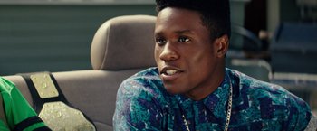 Movie still from “Dope” (2015), directed by Rick Famuyiwa – A person sitting in a chair; Close Up shot, Over the shoulder angle