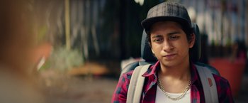 Movie still from “Dope” (2015), directed by Rick Famuyiwa – A young man wearing a hat and a backpack; Close Up shot, Over the shoulder angle