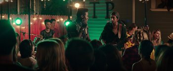 Movie still from “Dope” (2015), directed by Rick Famuyiwa – A group of young men performing on stage in front of an audience; Medium shot, Over the shoulder angle