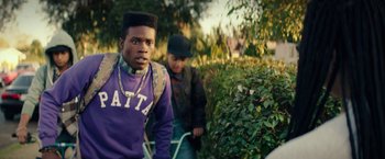 Movie still from “Dope” (2015), directed by Rick Famuyiwa – Two young men are walking through the bushes; Medium shot, Over the shoulder angle