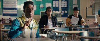 Movie still from “Dope” (2015), directed by Rick Famuyiwa – A group of people sitting at a table in a classroom; Medium shot, Over the shoulder angle