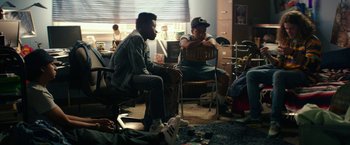 Movie still from “Dope” (2015), directed by Rick Famuyiwa – A group of people sitting in a room; Medium shot, High angle