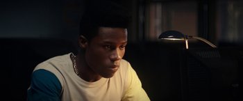 Movie still from “Dope” (2015), directed by Rick Famuyiwa – A young man sitting in front of a computer monitor; Close Up shot, Low angle