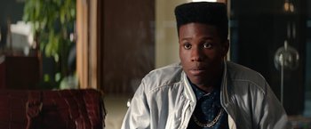 Movie still from “Dope” (2015), directed by Rick Famuyiwa – A man with a beard and a jacket on looking at the camera; Close Up shot, Over the shoulder angle