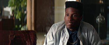 Movie still from “Dope” (2015), directed by Rick Famuyiwa – A young man with short black hair wearing a jacket; Close Up shot, Over the shoulder angle