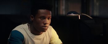 Movie still from “Dope” (2015), directed by Rick Famuyiwa – A man sitting in front of a lamp in a dark room; Close Up shot, Low angle