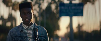 Movie still from “Dope” (2015), directed by Rick Famuyiwa – A man standing in front of a microphone on a street; Close Up shot, Low angle
