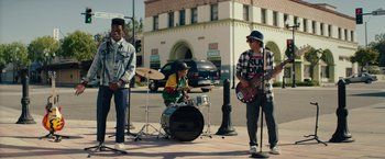 Movie still from “Dope” (2015), directed by Rick Famuyiwa – A group of young men playing instruments on the sidewalk; Wide shot, Low angle