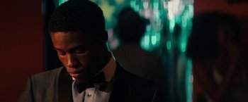 Movie still from “Dope” (2015), directed by Rick Famuyiwa – A man in a suit and bow tie looking to his left; Close Up shot, Over the shoulder angle