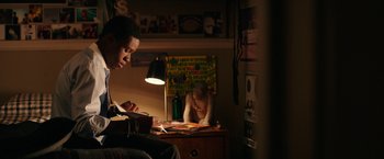 Movie still from “Dope” (2015), directed by Rick Famuyiwa – A young man sitting at a desk in front of a lamp; Medium shot, Low angle