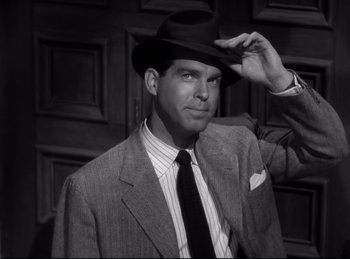 Movie still from “Double Indemnity” (1944), directed by Billy Wilder – A black and white photo of a man wearing a suit and hat; Medium shot, Low angle