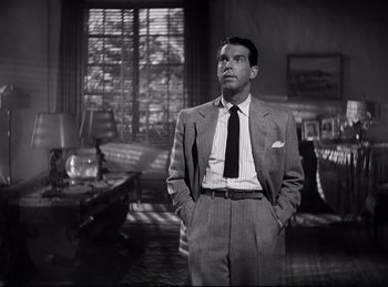 Movie still from “Double Indemnity” (1944), directed by Billy Wilder – A black and white photo of a man in a suit and tie; Medium shot, Low angle