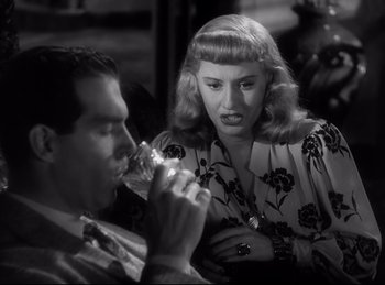 Movie still from “Double Indemnity” (1944), directed by Billy Wilder – A man and a woman sitting at a dinner table; Close Up shot, High angle