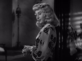 Movie still from “Double Indemnity” (1944), directed by Billy Wilder – A black and white photo of a woman in a floral blouse; Close Up shot, Over the shoulder angle