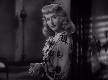 Movie still from “Double Indemnity” (1944), directed by Billy Wilder – A black and white photo of a woman in a floral dress; Close Up shot, Low angle