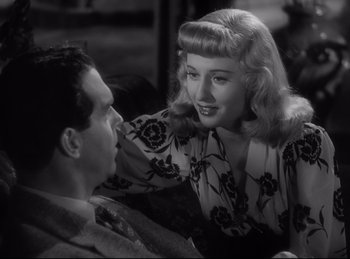 Movie still from “Double Indemnity” (1944), directed by Billy Wilder – A man and a woman sitting on a couch talking to each other; Close Up shot, High angle
