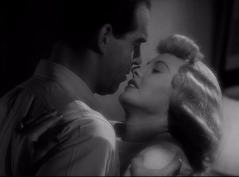 Movie still from “Double Indemnity” (1944), directed by Billy Wilder – A man and a woman are kissing in a black and white photo; Close Up shot, Low angle