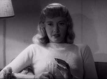 Movie still from “Double Indemnity” (1944), directed by Billy Wilder – A black and white photo of a woman holding a glass of wine; Close Up shot, Low angle