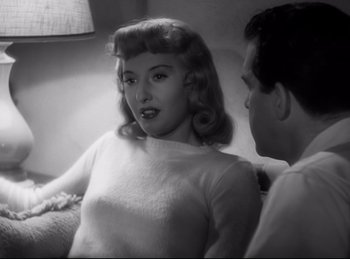Movie still from “Double Indemnity” (1944), directed by Billy Wilder – A woman sitting on a couch next to a man; Close Up shot, High angle