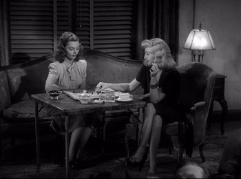 Movie still from “Double Indemnity” (1944), directed by Billy Wilder – A couple of women sitting at a dinner table together; Medium shot, High angle