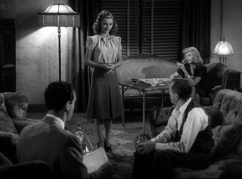 Movie still from “Double Indemnity” (1944), directed by Billy Wilder – A woman standing in front of a group of people; Medium shot, High angle