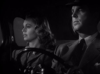 Movie still from “Double Indemnity” (1944), directed by Billy Wilder – A man and a woman sitting in a car; Close Up shot, Low angle