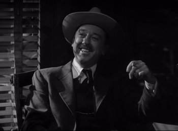 Movie still from “Double Indemnity” (1944), directed by Billy Wilder – A man wearing a suit and a cowboy hat; Close Up shot, Low angle