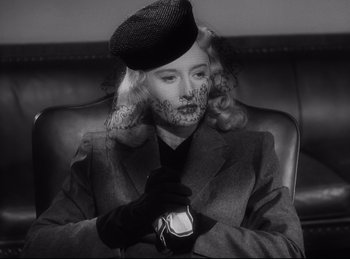 Movie still from “Double Indemnity” (1944), directed by Billy Wilder – A black and white photo of a woman wearing a hat and gloves; Close Up shot, Low angle