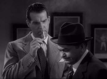 Movie still from “Double Indemnity” (1944), directed by Billy Wilder – A man in a suit and a man in a hat smoking a cigarette; Medium shot, Low angle